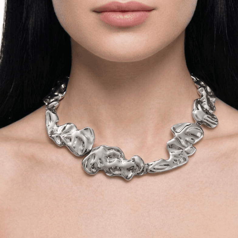 The collar worn at the base of a woman's throat, sitting flat against the collarbone, on a white backdrop.